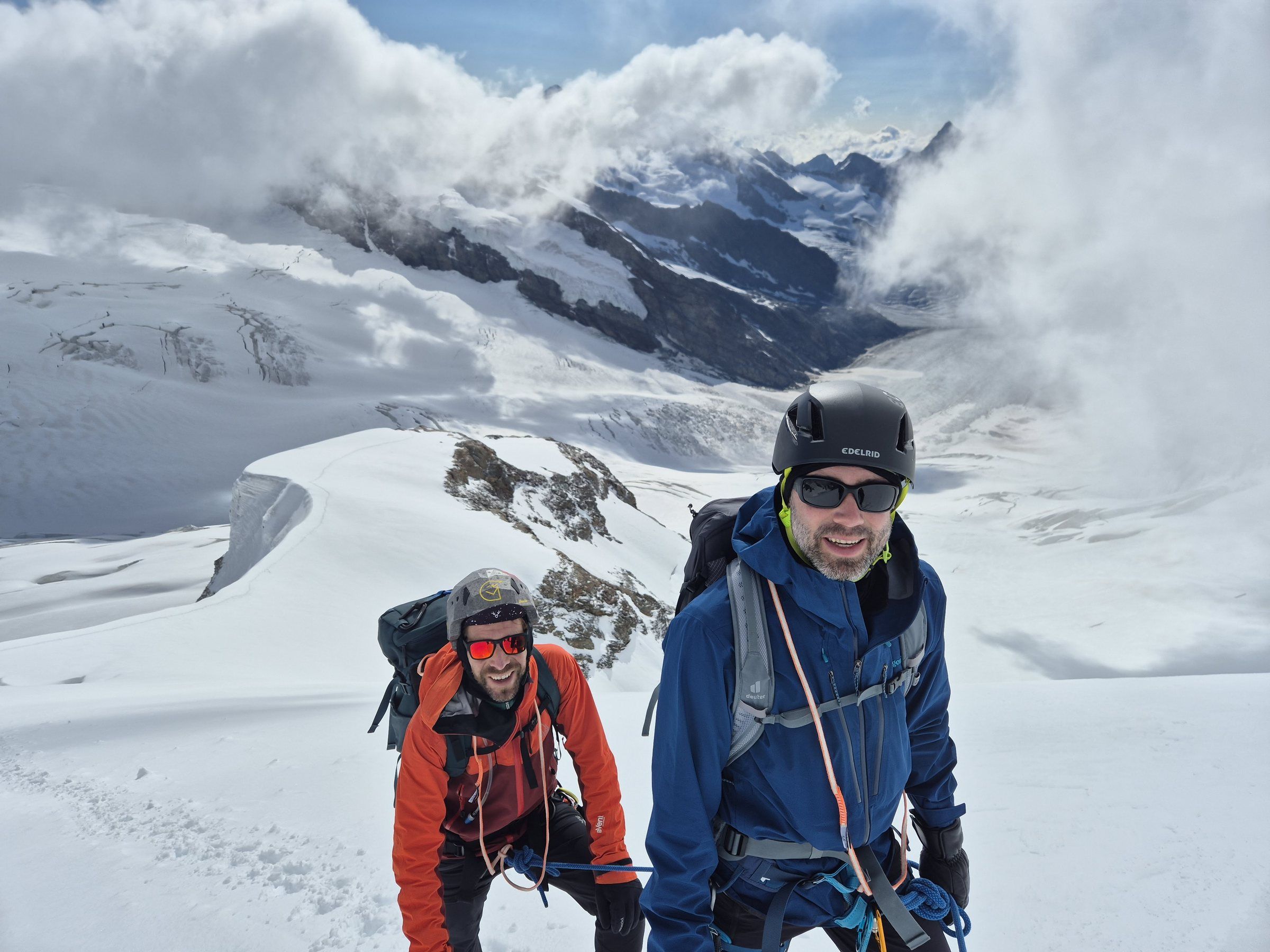 Zwei lachende Bergsteiger mit Helm auf dem Gletscher