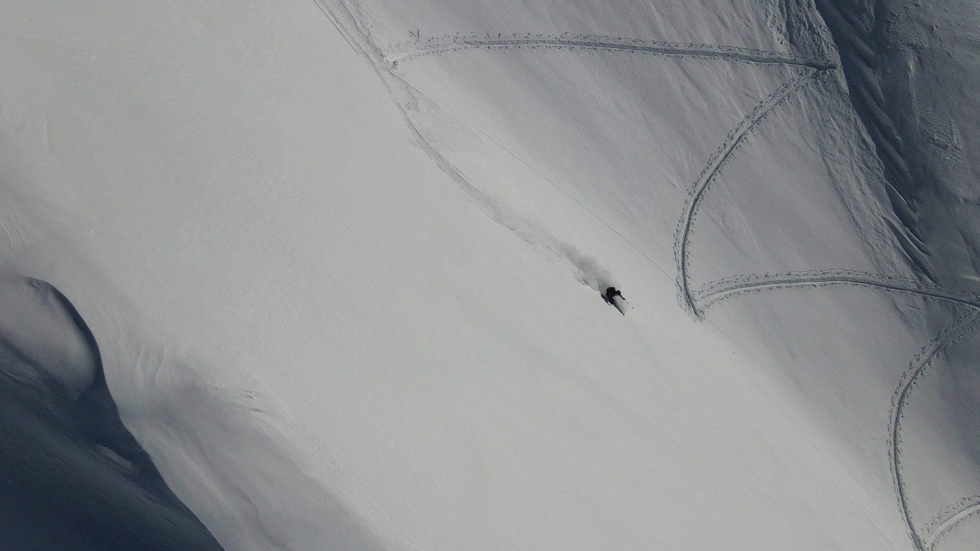 Skispuren in einem weiten Hang, von oben