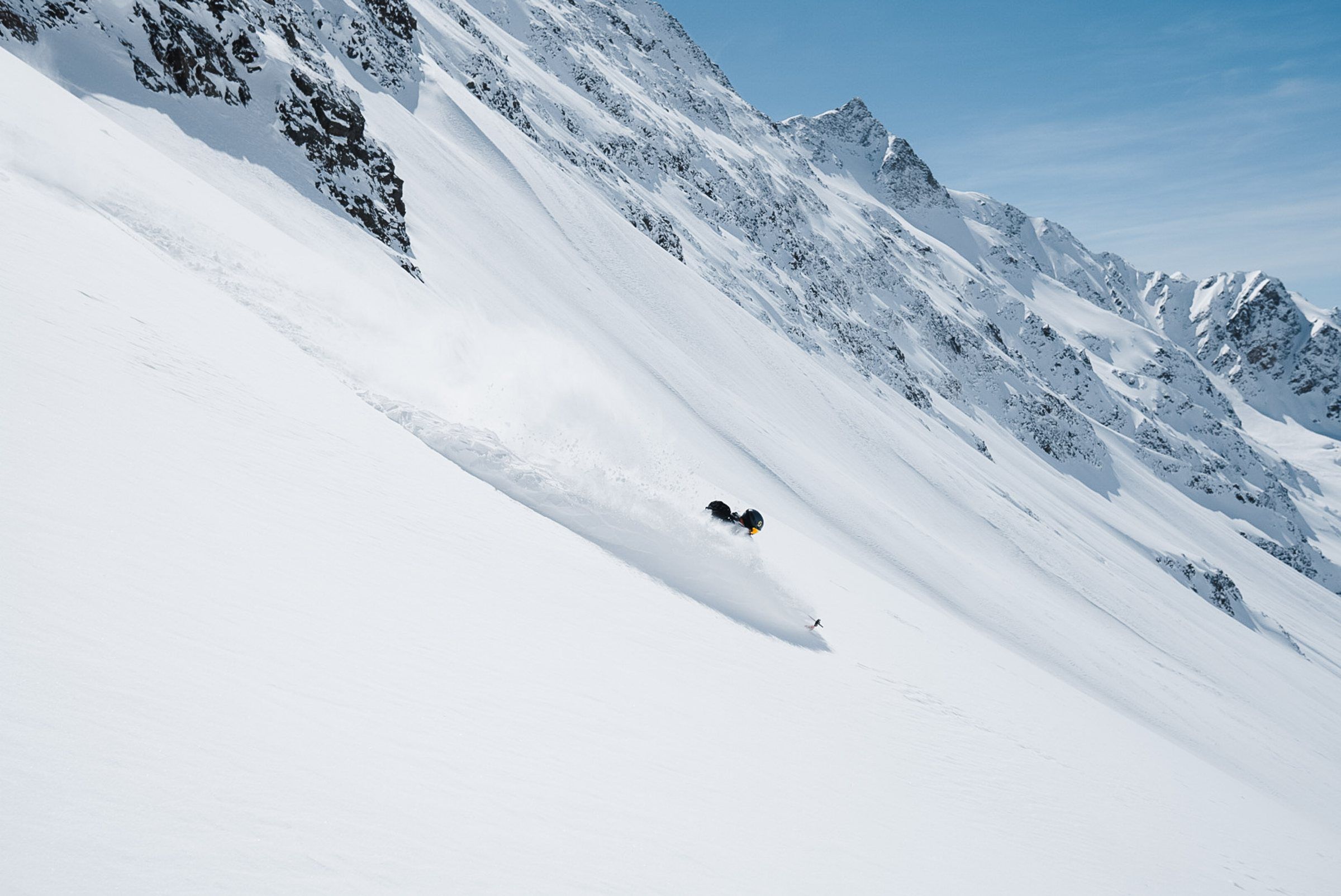 Skifahrer zieht eine Spur in einen steilen Hang